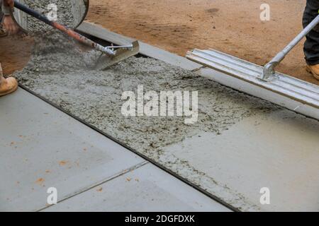 Bauarbeiter Verlegung Betonmischer mit Betonmischer auf Bürgersteig Stockfoto