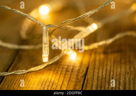 Сhristmas Lichter auf dem rustikalen Holzhintergrund. Selektiver Fokus. Geringe Schärfentiefe. Stockfoto