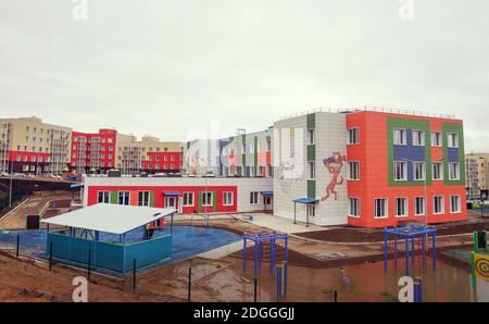 Zwischen Wohngebäuden im Arbeiterdorf Taezhny im Gebiet Krasnojarsk steht ein neu errichener Kindergarten, der noch nicht in Betrieb genommen wurde. Russland Stockfoto