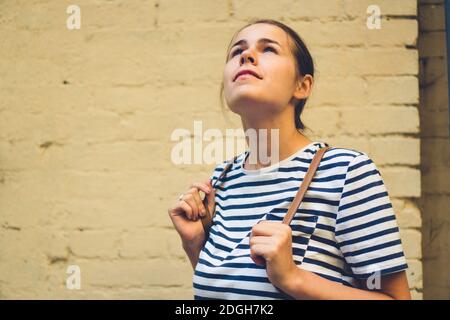 Junge positive Touristen Frau im Straßenstil gekleidet tragen stehen Wand Hintergrund, lächelnd Hipster Mädchen in trendigen lässigen cothin Stockfoto