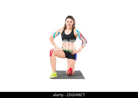 Erstaunlich stärkere Sport Fitness Frau machen Übungen isoliert über weiße Wand Hintergrund. Kinesio-Band. Thema Kinesiologie Band r Stockfoto