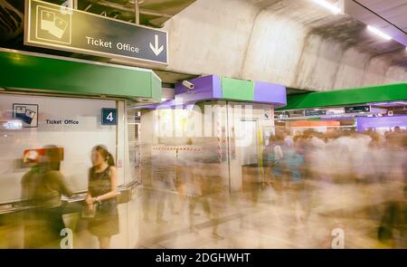 Touristen im Flughafenterminal, verschwommene Sicht mit sich schnell bewegenden Menschen. Urlaubs- und Reisekonzept Stockfoto