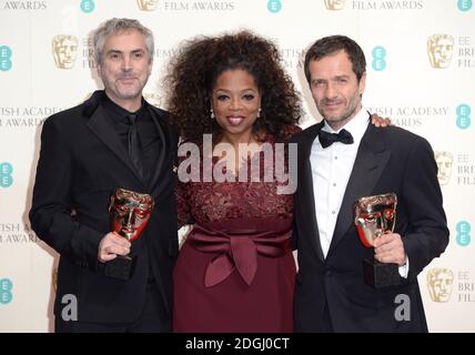 Alfonso Cuaron (links), David Heyman (rechts) mit dem Best British Film Award für "Gravity", zusammen mit Moderator Oprah Winfrey, bei den EE British Academy Film Awards 2014, im Royal Opera House, Bow Street, London. Stockfoto