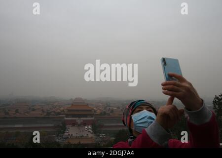 --FILE--Blick nach unten aus Wanchun Pavillon im Jingshan Park, die Verbotene Stadt ist in Smog gehüllt, und die gelbe Warnung für schwere Luftverschmutzung ist s Stockfoto