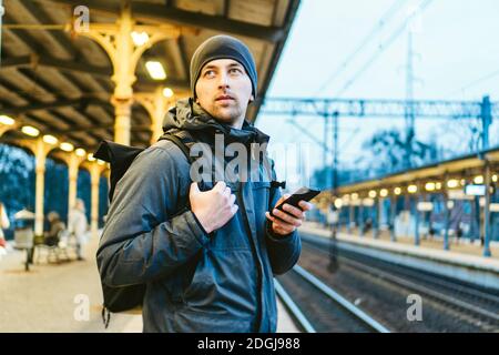 Sopot Fast Urban Bahnhof. Junger Mann steht und wartet Zug auf Plattform. Tourist reist mit dem Zug. Porträt Von Caucas Stockfoto