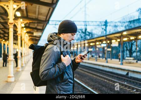 Sopot Fast Urban Bahnhof. Junger Mann steht und wartet Zug auf Plattform. Tourist reist mit dem Zug. Porträt Von Caucas Stockfoto