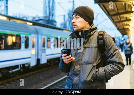 Sopot Fast Urban Bahnhof. Junger Mann steht und wartet Zug auf Plattform. Tourist reist mit dem Zug. Porträt Von Caucas Stockfoto