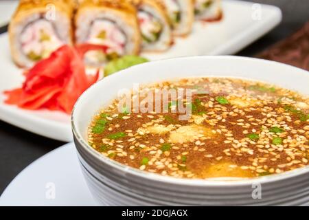 Japanische Miso-Suppe und Sushi-Rollen auf dem Hintergrund Stockfoto