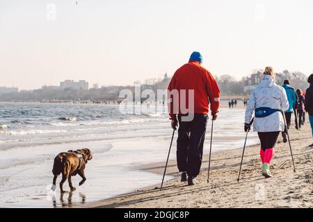 Polen, Sopot, 9. Februar 2020. Menschen am Strand in Sopot. Menge am Strand im Winter. Genießen Sie den Tag im sonnigen Winter in der Nähe des Meeres. Stockfoto