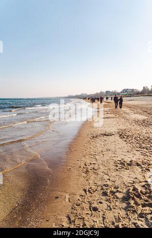 Polen, Sopot, 9. Februar 2020. Menschen am Strand in Sopot. Menge am Strand im Winter. Genießen Sie den Tag im sonnigen Winter in der Nähe des Meeres. Stockfoto