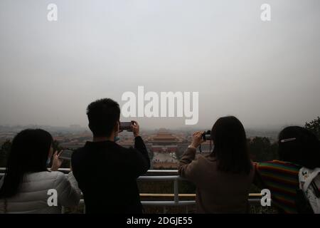 --FILE--Blick nach unten aus Wanchun Pavillon im Jingshan Park, die Verbotene Stadt ist in Smog gehüllt, und die gelbe Warnung für schwere Luftverschmutzung ist s Stockfoto