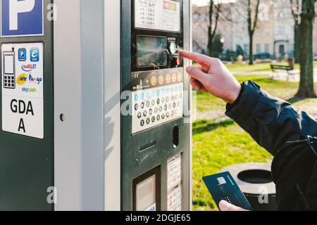 Man zahlt für das Parken mit einer Kreditkarte mit NFS-Technologie. Einfache Zahlung. Zahlungsprozess im Automatenparkplatz. Zahler Stockfoto