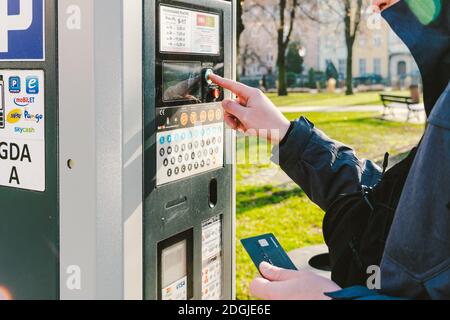 Man zahlt für das Parken mit einer Kreditkarte mit NFS-Technologie. Einfache Zahlung. Zahlungsprozess im Automatenparkplatz. Zahler Stockfoto