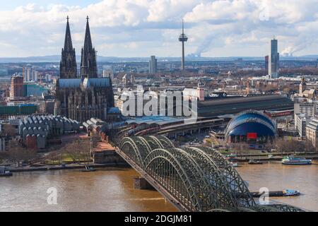 Panorama-Stadtbild über den Rhein der Kölner Stadt (Kölner Dom, Hohenzollernbrücke und Colonius) Wolkenverhangener blauer und weißer Himmel im Hintergrund. Stockfoto