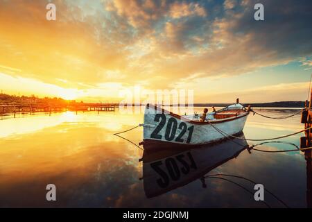 2021 Konzept Fischerboot auf Varna See mit einer Reflexion im Wasser bei Sonnenuntergang. Stockfoto