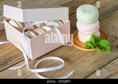 Geschenkbox mit hausgemachten Pastellfarben Marshmallows. Apfel zephyr in runder Form. Leckeres Fruchtdessert auf Holztisch. Stockfoto