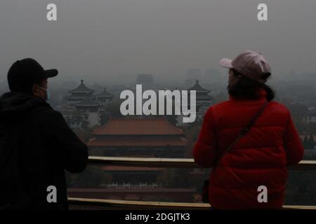 --FILE--Blick nach unten aus Wanchun Pavillon im Jingshan Park, die Verbotene Stadt ist in Smog gehüllt, und die gelbe Warnung für schwere Luftverschmutzung ist s Stockfoto