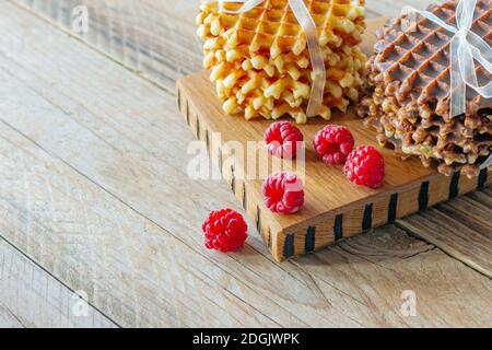 Köstliche belgische Waffeln mit einer Beere auf einem Holzbrett. Leckeres Frühstück. Stockfoto