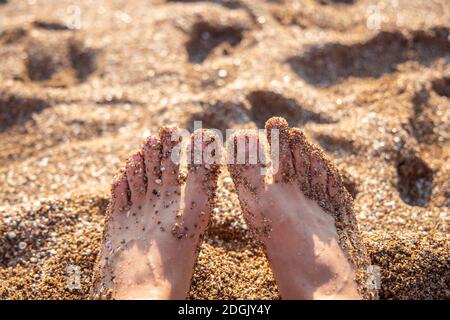 Mann männliche Füße am Sandstrand. Nahaufnahme barfuß relaxen am Strand in Antalya Türkei. Reise- und Urlaubskonzept. Stockfoto