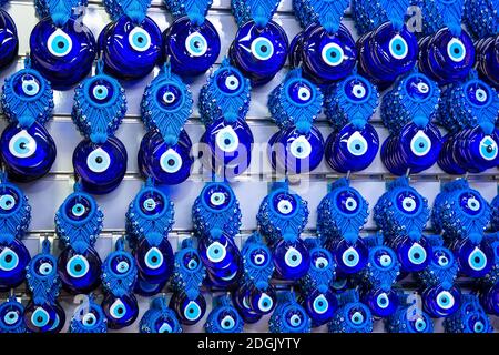 Verschiedene blaue Amulette böse Augenperlen nazar boncugu Hanging on Der weiße Wandhintergrund in antalya türkei Stockfoto