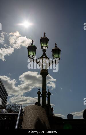 Ein verzierter Lampenpfosten, der von der Sonne auf der Westminster Bridge, London, England, beleuchtet wird Stockfoto