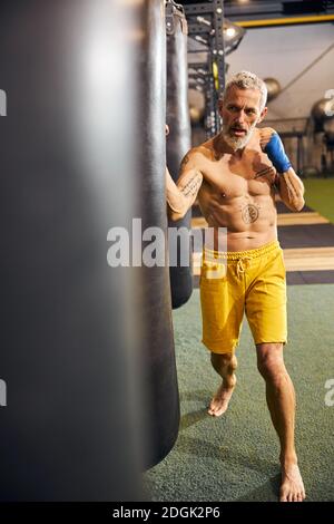 Ernst grauhaarige barfuß kaukasischen Sportler üben Kickboxen Stockfoto