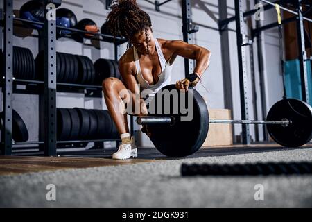 Starke athletische Dame, die sich für das Gewichtheben-Workout vorbereitet Stockfoto