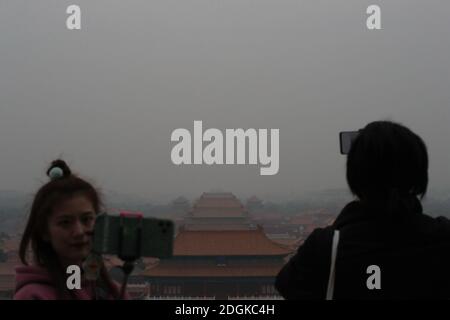 --FILE--Blick nach unten aus Wanchun Pavillon im Jingshan Park, die Verbotene Stadt ist in Smog gehüllt, und die gelbe Warnung für schwere Luftverschmutzung ist s Stockfoto