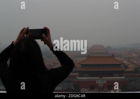 --FILE--Blick nach unten aus Wanchun Pavillon im Jingshan Park, die Verbotene Stadt ist in Smog gehüllt, und die gelbe Warnung für schwere Luftverschmutzung ist s Stockfoto