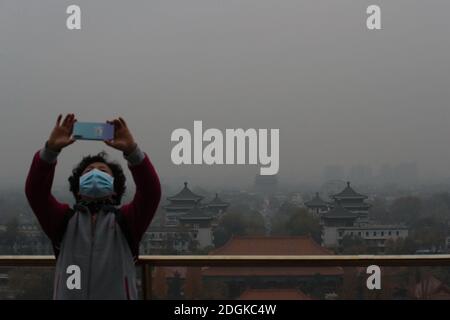 --FILE--Blick nach unten aus Wanchun Pavillon im Jingshan Park, die Verbotene Stadt ist in Smog gehüllt, und die gelbe Warnung für schwere Luftverschmutzung ist s Stockfoto