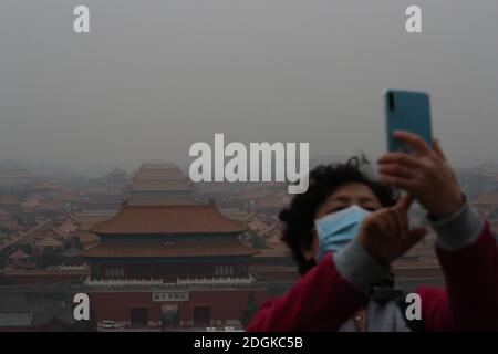 --FILE--Blick nach unten aus Wanchun Pavillon im Jingshan Park, die Verbotene Stadt ist in Smog gehüllt, und die gelbe Warnung für schwere Luftverschmutzung ist s Stockfoto