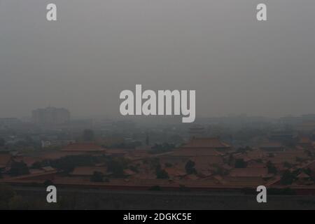 --FILE--Blick nach unten aus Wanchun Pavillon im Jingshan Park, die Verbotene Stadt ist in Smog gehüllt, und die gelbe Warnung für schwere Luftverschmutzung ist s Stockfoto