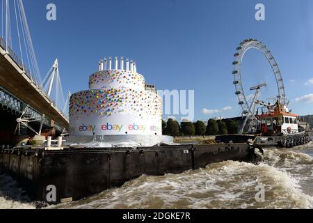 EBay feierte seinen 20. Geburtstag, indem er einen 6m hohen Kuchen, größer als ein Doppeldeckerbus, mit 20 Kerzen auf der Oberseite, die Themse in London von Greenwich nach Battersea hinunter schwebt. Sie führte an berühmten Londoner Wahrzeichen wie Tower Bridge, O2, London Eye, Walkie Talkie Building, Shard und Battersea Power Station vorbei. Stockfoto