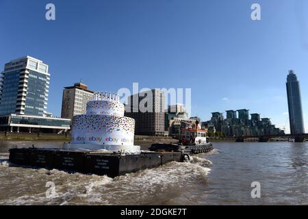 EBay feierte seinen 20. Geburtstag, indem er einen 6m hohen Kuchen, größer als ein Doppeldeckerbus, mit 20 Kerzen auf der Oberseite, die Themse in London von Greenwich nach Battersea hinunter schwebt. Sie führte an berühmten Londoner Wahrzeichen wie Tower Bridge, O2, London Eye, Walkie Talkie Building, Shard und Battersea Power Station vorbei. Stockfoto