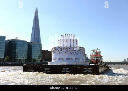 EBay feierte seinen 20. Geburtstag, indem er einen 6m hohen Kuchen, größer als ein Doppeldeckerbus, mit 20 Kerzen auf der Oberseite, die Themse in London von Greenwich nach Battersea hinunter schwebt. Sie führte an berühmten Londoner Wahrzeichen wie Tower Bridge, O2, London Eye, Walkie Talkie Building, Shard und Battersea Power Station vorbei. Stockfoto