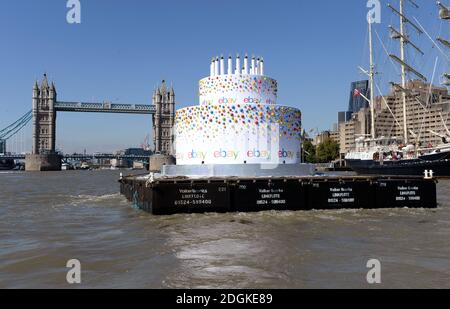 EBay feierte seinen 20. Geburtstag, indem er einen 6m hohen Kuchen, größer als ein Doppeldeckerbus, mit 20 Kerzen auf der Oberseite, die Themse in London von Greenwich nach Battersea hinunter schwebt. Sie führte an berühmten Londoner Wahrzeichen wie Tower Bridge, O2, London Eye, Walkie Talkie Building, Shard und Battersea Power Station vorbei. Stockfoto