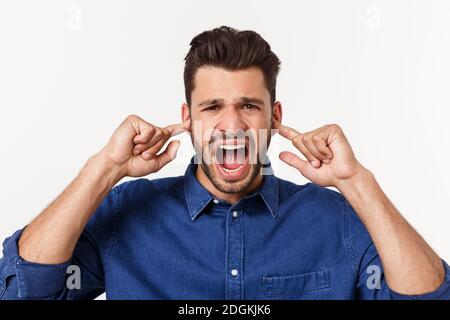 Nahaufnahme des enttäuschten gestressten bärtigen jungen Mannes im Hemd über weißem Hintergrund. Stockfoto