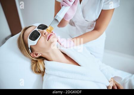 Frau, die sich der fraktionalen Laser-Hautbehandlung unterziehen Stockfoto