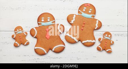Lustige Grußkarte mit Lebkuchen Mann Cookies in medizinischen Gesichtsmaske. Flach liegend Stockfoto