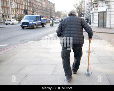 London, England, Großbritannien. Alter Mann mit gebeugten Beinen und einem Gehstock in der Marylebone Road Stockfoto