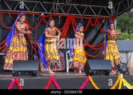 Gruppe von indischen Frauen in bunten Saris tanzen auf der Bühne während Diwali, dem hinduistischen Festival des Lichts Stockfoto