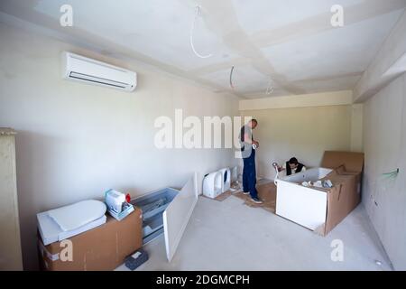 Professioneller Klempner, der in einem Badezimmer arbeitet Stockfoto