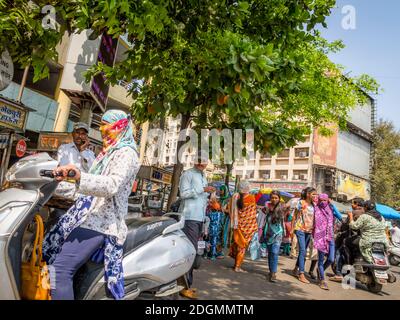 PUNE, INDIEN - 14. MÄRZ 2019: Frau auf Moped auf einer belebten Straße in Pune, Staat Maharashtra, Indien Stockfoto