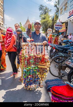 PUNE, INDIEN - 14. MÄRZ 2019: Souvenirverkäufer und Passanten in Pune, Indien Stockfoto