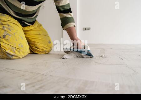 Fliesenleger füllen den Raum zwischen keramischen Holz-Effekt Fliesen Stockfoto