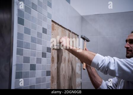 Arbeiter entfernen die alten Fliesen im Badezimmer abreißen Stockfoto