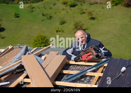 Bauarbeiter, der ein neues Dach installiert Stockfoto