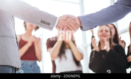Kreative junge Geschäftsleute schütteln sich gegenseitig die Hände. Stockfoto
