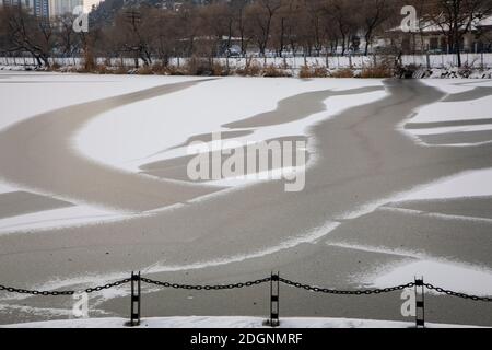Viele geheimnisvolle schwarz-weiße Muster ohne Schnee erscheinen Auf dem gefrorenen künstlichen See, der wie ein natürliches aussieht Tusche waschen Malerei in Beishan Sce Stockfoto