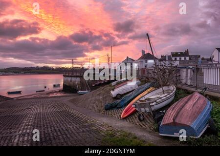 Appledore, North Devon, England. Mittwoch, 9. Dezember 2020. Wetter in Großbritannien. Eine Pause in der schweren Nachtwolke erzeugt einen bunten Vordämmerungshimmel über den kleinen Booten, die am Kai im Küstendorf Appledore in North Devon gebunden sind. Quelle: Terry Mathews/Alamy Live News Stockfoto